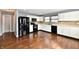 Eat-in kitchen with white cabinets, black appliances, and hardwood flooring throughout at 5005 Whisenand Dr, Indianapolis, IN 46254