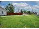 Spacious backyard featuring a well-maintained lawn, a red fence for privacy, and ample space for outdoor activities at 52 N Ross St, Columbus, IN 47201