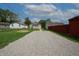Backyard featuring lush grass, gravel driveway, and mature trees at 52 N Ross St, Columbus, IN 47201