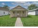 Attractive single-story home featuring a covered porch and green front lawn at 52 N Ross St, Columbus, IN 47201