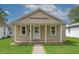 Charming single-story home with neutral siding, front porch and well-maintained lawn at 52 N Ross St, Columbus, IN 47201