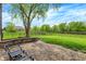 Spacious backyard featuring a well-maintained lawn, patio, trees, and black metal fencing at 5942 Tioga Ct, Bargersville, IN 46106