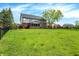 Expansive backyard with lush green lawn, mature trees, black metal fencing, and a screened-in porch at 5942 Tioga Ct, Bargersville, IN 46106