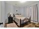 Cozy bedroom featuring a wrought iron bed frame, hardwood floors, and a lamp-lit nightstand at 5942 Tioga Ct, Bargersville, IN 46106