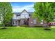 Beautiful brick home with a red door, manicured lawn, and lush landscaping at 5942 Tioga Ct, Bargersville, IN 46106