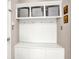 Mudroom with white storage bench, coat hooks, shelving, and striped storage bins at 5942 Tioga Ct, Bargersville, IN 46106