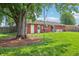 Spacious backyard features a well-maintained lawn, a seating area, and a large shady tree at 5987 E 100 N, Franklin, IN 46131