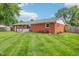 Scenic view of the backyard showcasing the well-kept lawn and attractive brick exterior of the home at 5987 E 100 N, Franklin, IN 46131