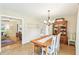 Light-filled dining room showcases a wooden table, white chairs, and hardwood floors in herringbone pattern at 5987 E 100 N, Franklin, IN 46131