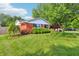 Landscaped front yard of a red brick house, featuring colorful roses and mature trees at 5987 E 100 N, Franklin, IN 46131