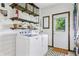 Functional laundry room with shelving, shiplap walls, and a door to the outside at 5987 E 100 N, Franklin, IN 46131