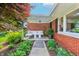 Charming porch area with comfortable white seating, red brick, and neatly landscaped front yard at 5987 E 100 N, Franklin, IN 46131