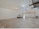 Large empty garage with white walls and floor and a golf cart with the door open at 6086 W 850 S, Edinburgh, IN 46124