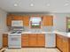 Bright kitchen featuring wood cabinetry, white appliances, and a window with a pleasant view at 6086 W 850 S, Edinburgh, IN 46124