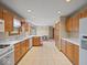 Open concept kitchen with wood cabinetry, bright countertops and tile floor leading to dining space at 6086 W 850 S, Edinburgh, IN 46124