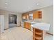 Well-lit kitchen with white appliances, wood cabinets, and tile flooring, offering lots of space at 6086 W 850 S, Edinburgh, IN 46124