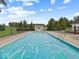Large pool with a safety cover surrounded by a black metal fence and trees under a blue sky at 6086 W 850 S, Edinburgh, IN 46124