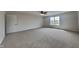 Large primary bedroom with neutral carpet, ceiling fan, and window offering ample natural light at 6420 Greenspire Pl, Indianapolis, IN 46221