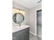 Updated bathroom featuring a modern vanity, stylish round mirror, and bright lighting at 6837 W Burlington Dr, McCordsville, IN 46055