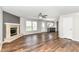 Spacious open-concept living area featuring wood floors and views to the kitchen and fireplace at 6837 W Burlington Dr, McCordsville, IN 46055