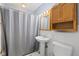 Cozy bathroom featuring a pedestal sink, tiled walls, and a wood medicine cabinet at 7 Lake Hart, Mooresville, IN 46158
