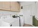 Functional laundry room with modern washer and dryer and ample cabinet space at 7 Lake Hart, Mooresville, IN 46158