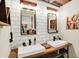 Modern bathroom featuring double sinks with an open wooden shelf, white subway tiles and exposed beam ceiling at 735 Lexington Ave # Apt 27, Indianapolis, IN 46203