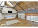Loft bedroom with exposed beams, skylights, a bed, and a lounge area under a metal beam construction at 735 Lexington Ave # Apt 27, Indianapolis, IN 46203