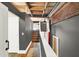 Hallway with wooden floors, gray walls, and access to a staircase at 735 Lexington Ave # Apt 27, Indianapolis, IN 46203