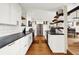 Modern kitchen featuring white cabinets, stainless steel appliances, and a rustic bar area at 735 Lexington Ave # Apt 27, Indianapolis, IN 46203