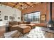 Spacious living room featuring exposed brick walls, wood ceilings, and modern furnishings at 735 Lexington Ave # Apt 27, Indianapolis, IN 46203