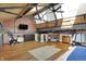 Spacious living room in an industrial loft featuring exposed brick, wooden beams, and a modern media center at 735 Lexington Ave # Apt 27, Indianapolis, IN 46203