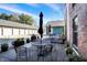 Charming patio with iron table, chairs, and potted plants in front of brick buildings and garages at 735 Lexington Ave # Apt 27, Indianapolis, IN 46203