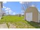 Expansive backyard showcasing a storage shed, lush green lawn, and partial fencing, enhancing outdoor appeal at 7907 Oakdale Ln, Indianapolis, IN 46214