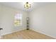 Bright, empty bedroom with a light fixture, window, and wood flooring at 7907 Oakdale Ln, Indianapolis, IN 46214