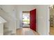 Bright foyer featuring a red front door, wood flooring, and staircase leading to the upper level at 7907 Oakdale Ln, Indianapolis, IN 46214