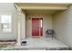 Inviting front porch with a red door, chair, and neutral siding for a cozy entrance at 7907 Oakdale Ln, Indianapolis, IN 46214