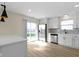 Open kitchen features white cabinets, stainless steel appliances, island counter, and a sliding glass door at 7907 Oakdale Ln, Indianapolis, IN 46214