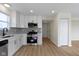 Bright kitchen features stainless steel appliances, white cabinets, gray subway tile backsplash, and wood floor at 7907 Oakdale Ln, Indianapolis, IN 46214