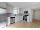 Beautiful bright kitchen with stainless steel appliances, white cabinets, modern fixtures and wood floor at 7907 Oakdale Ln, Indianapolis, IN 46214