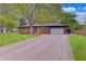 Charming brick home with an attached garage and mature trees accentuating the front lawn at 8049 Burn Ct, Indianapolis, IN 46217