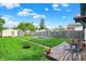 Spacious backyard with a wooden deck, metal garden beds, and mature trees at 844 N Emerson Ave, Indianapolis, IN 46219