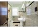 Clean bathroom featuring a pedestal sink, black and white tiled floors, and natural light at 844 N Emerson Ave, Indianapolis, IN 46219