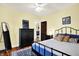 Comfortable bedroom with a metal bed frame, dark wood furniture, and lots of natural light at 844 N Emerson Ave, Indianapolis, IN 46219