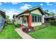 Charming yellow house featuring colorful awnings, landscaped yard and beautiful flower arrangements at 844 N Emerson Ave, Indianapolis, IN 46219