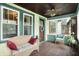 Inviting enclosed front porch with tiled flooring, comfortable seating, and plenty of natural light at 844 N Emerson Ave, Indianapolis, IN 46219
