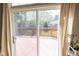 View of a well-maintained backyard through sliding glass doors, featuring a red wooden fence and lush greenery at 9718 Jupiter Pass, Carmel, IN 46032