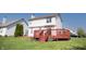 Backyard view of a two-story home with a stained wood deck and manicured lawn at 9718 Jupiter Pass, Carmel, IN 46032