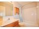Modest bathroom features a shower with blue curtain, wooden cabinets, and white sink at 9718 Jupiter Pass, Carmel, IN 46032