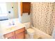 Cozy bathroom featuring a vanity with storage, a toilet, and a shower/tub with a cheerful cherry-patterned curtain at 9718 Jupiter Pass, Carmel, IN 46032